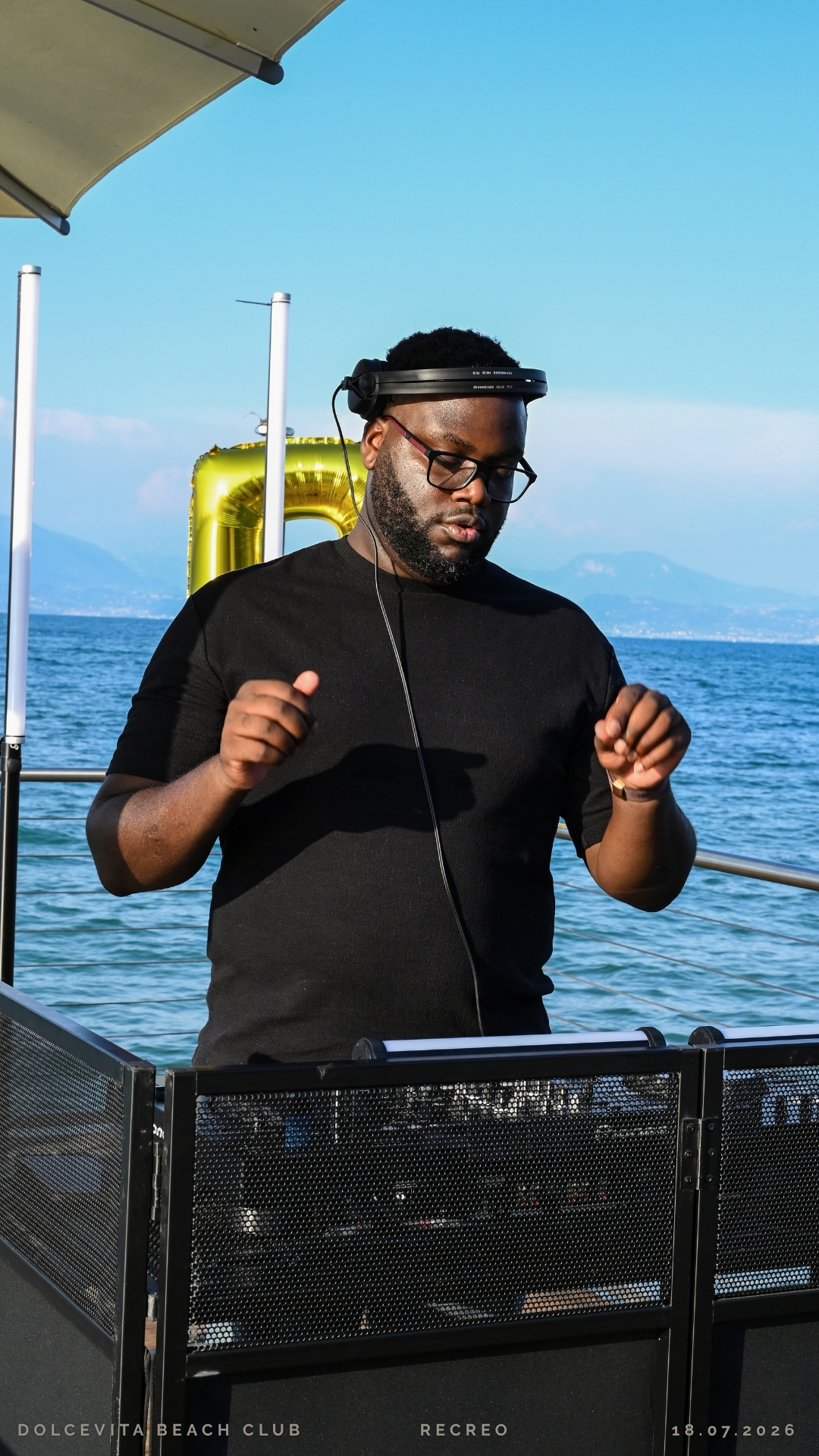 Dj balla in consolle davanti al Lago di Garda