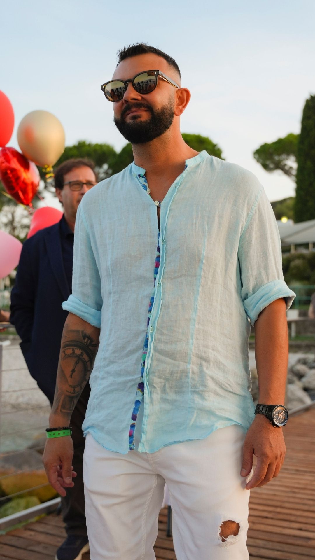 Ospite con camicia azzurra e occhiali da sole