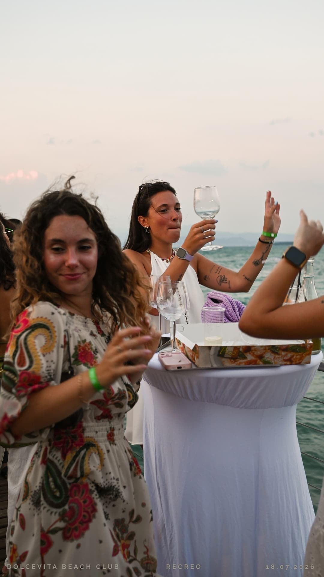 Ragazze brindano attorno al tavolo alto