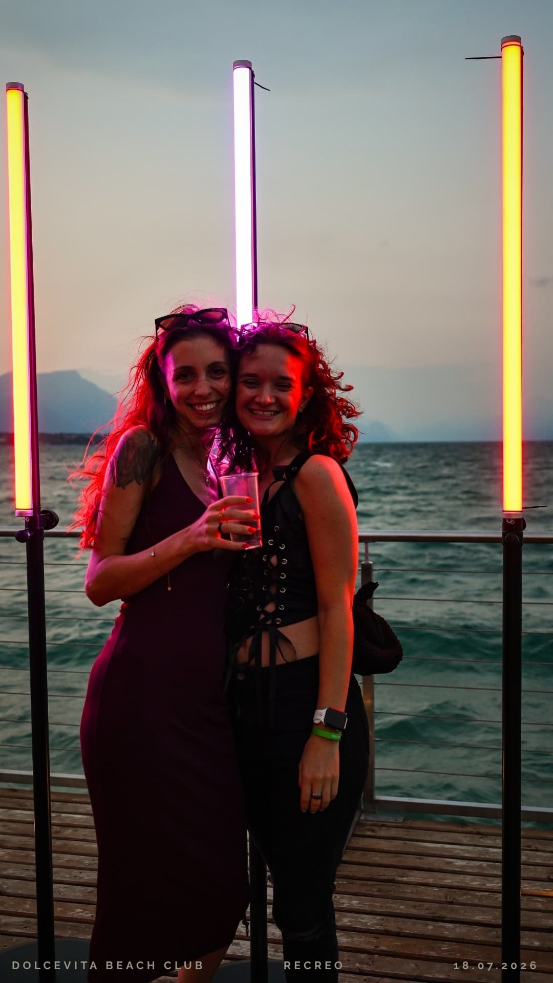 Due amiche sorridono tra le luci al neon