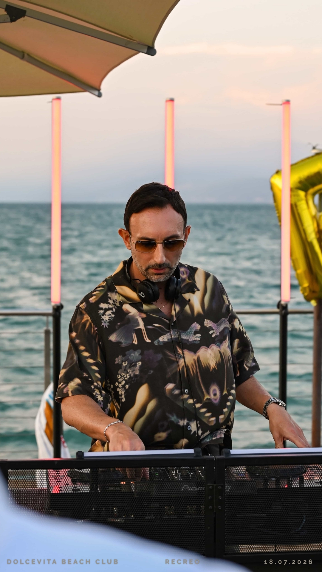 Dj mixa sotto le luci al tramonto