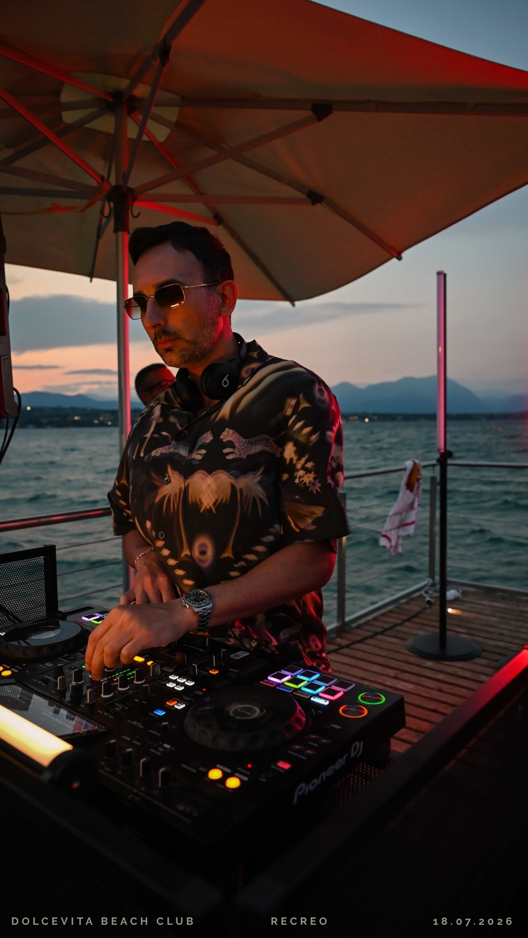 Dj alla consolle illuminato dalle luci rosse