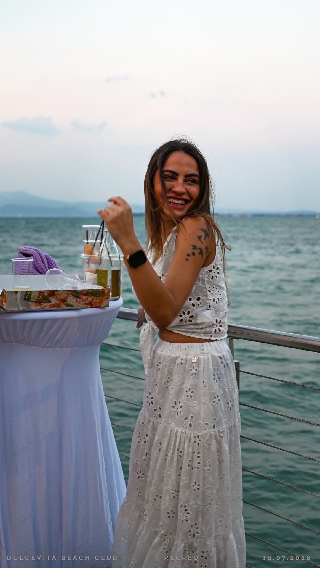 Ragazza sorride accanto al tavolo sul pontile