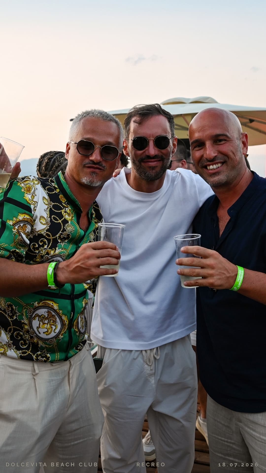 Tre amici brindano insieme al tramonto