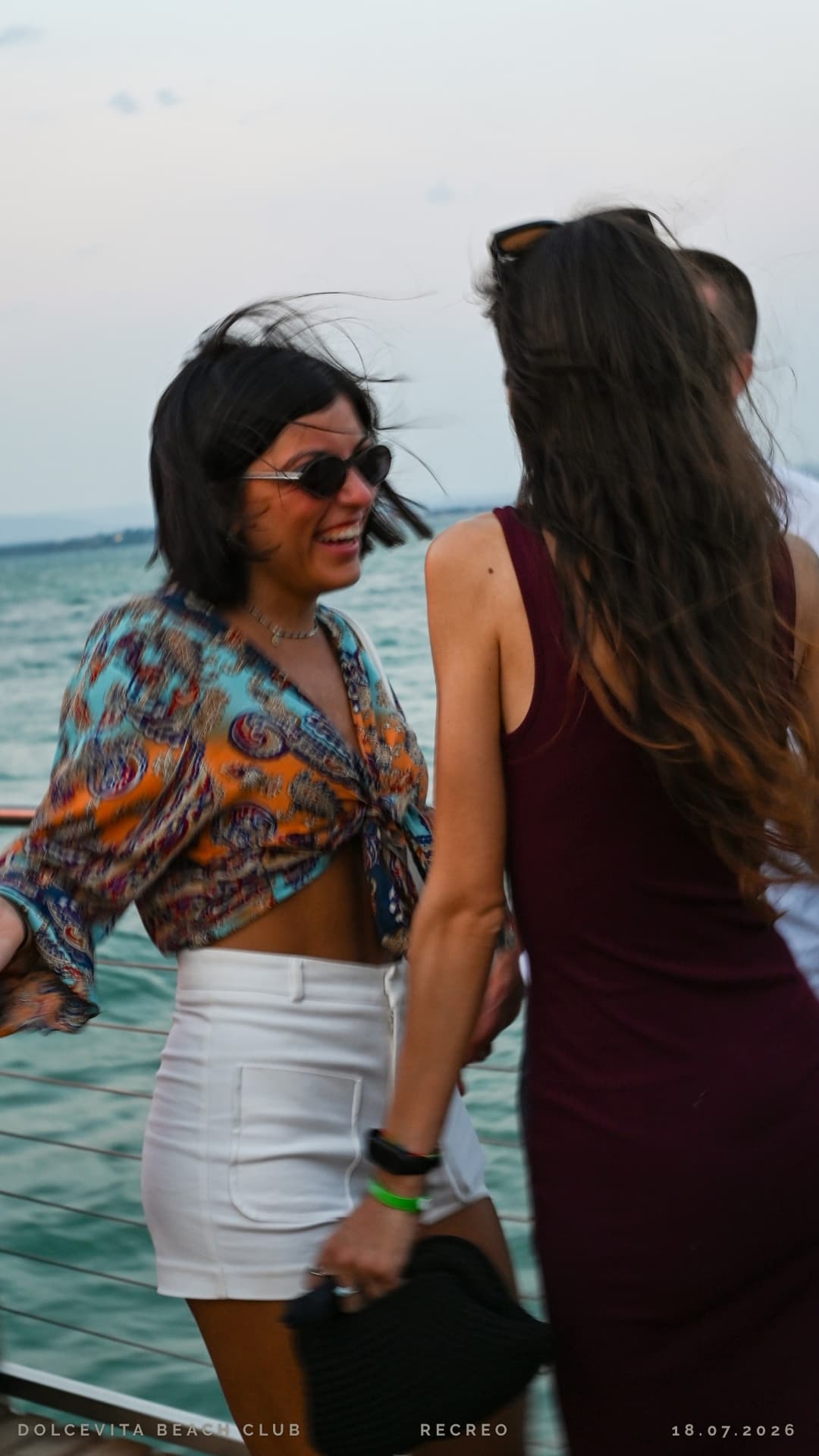 Due amiche camminano ridendo lungo il pontile