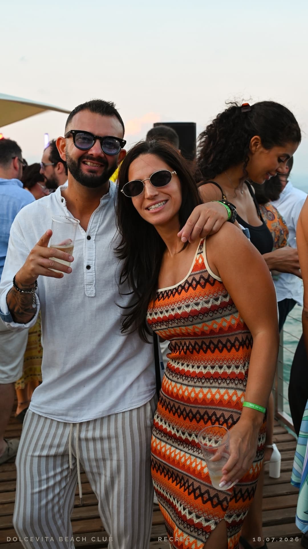 Coppia sorridente in posa con i bicchieri