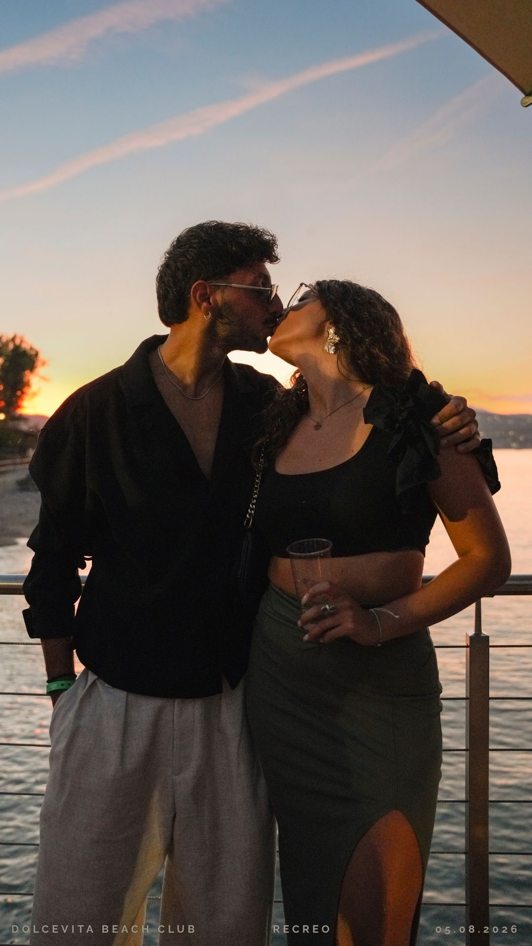 Coppia si bacia sul pontile al tramonto