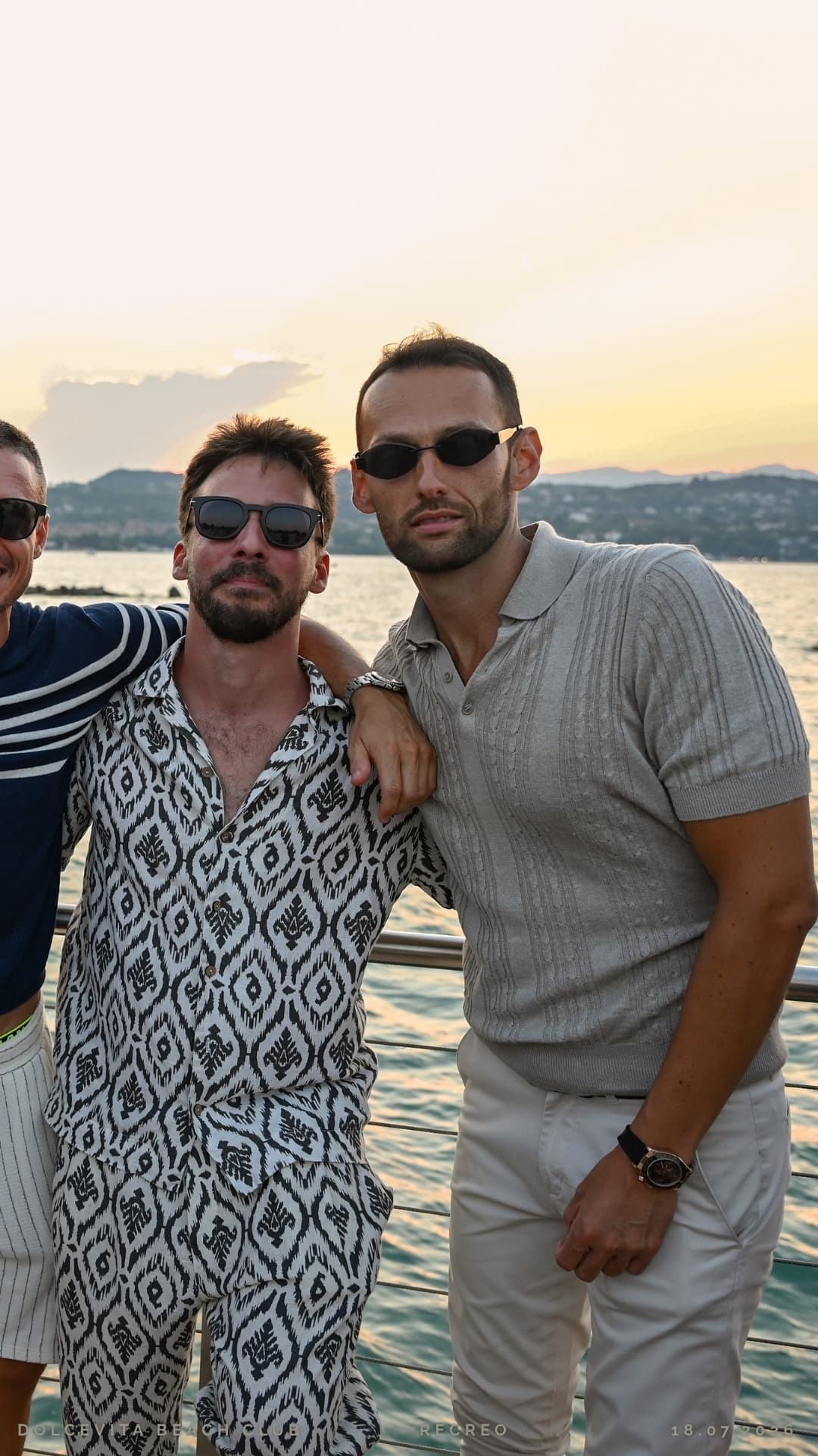 Tre amici posano al tramonto sul pontile