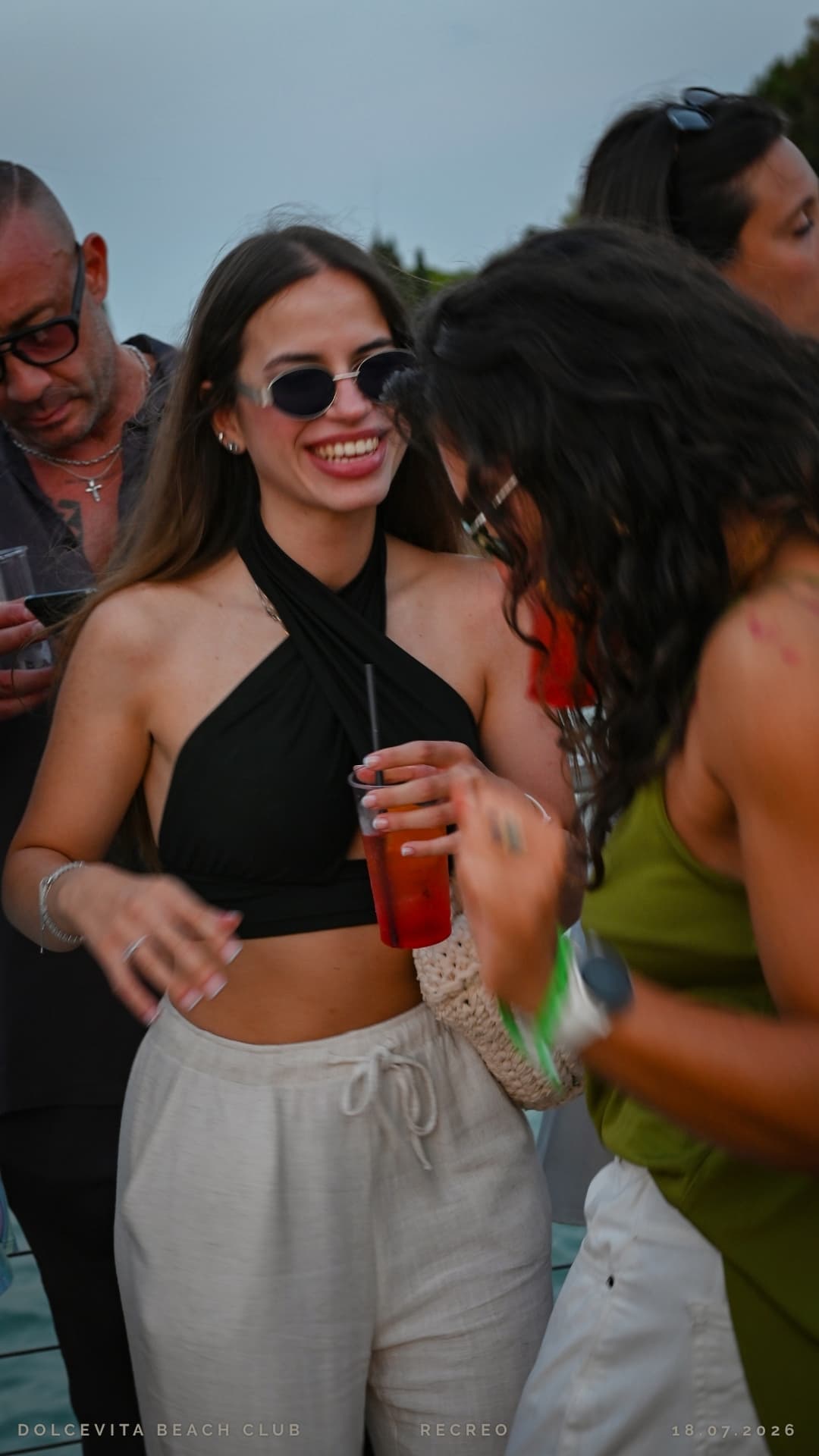 Ragazza sorride con un cocktail in mano