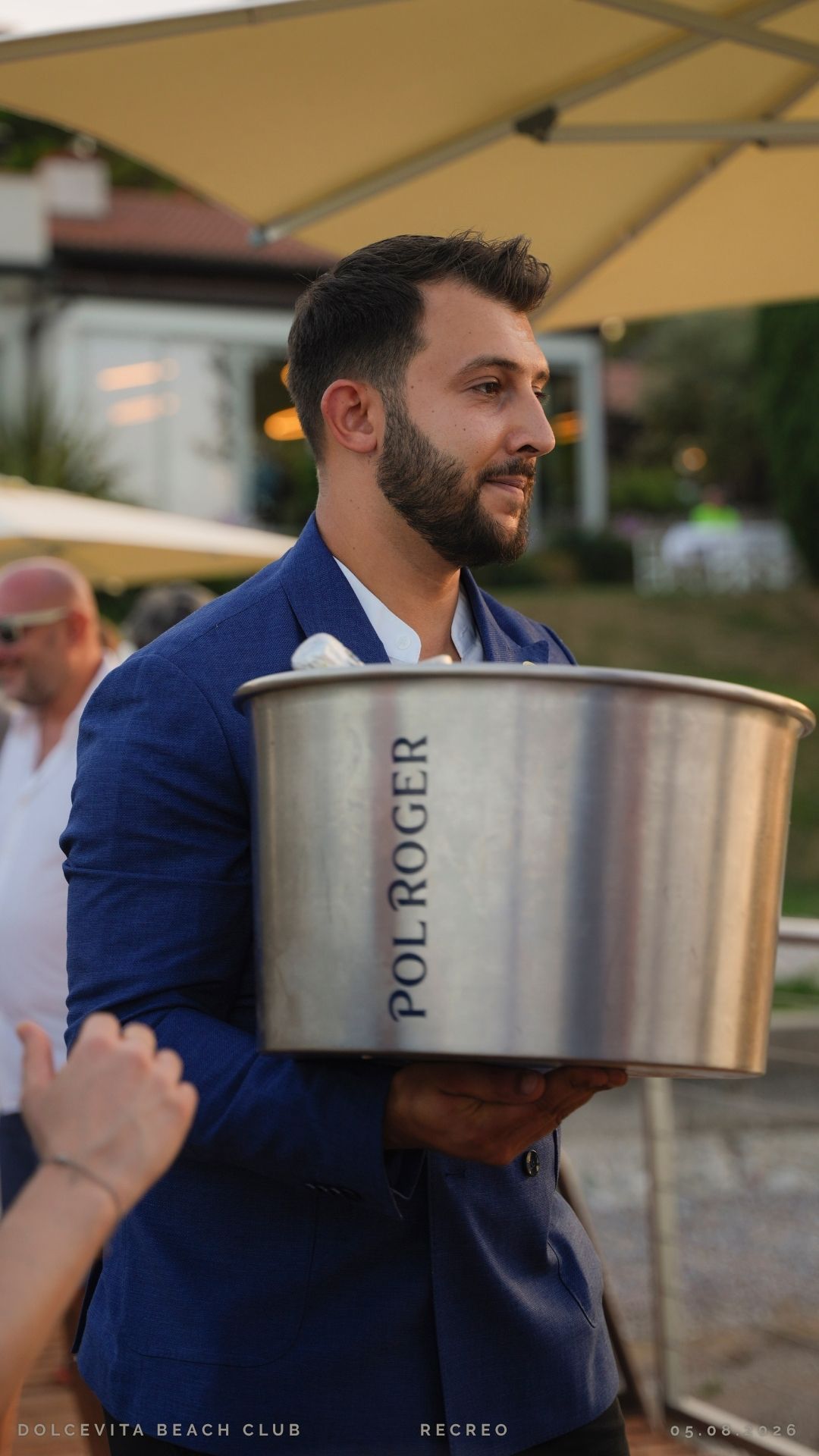 Cameriere in giacca blu con secchiello Pol Roger
