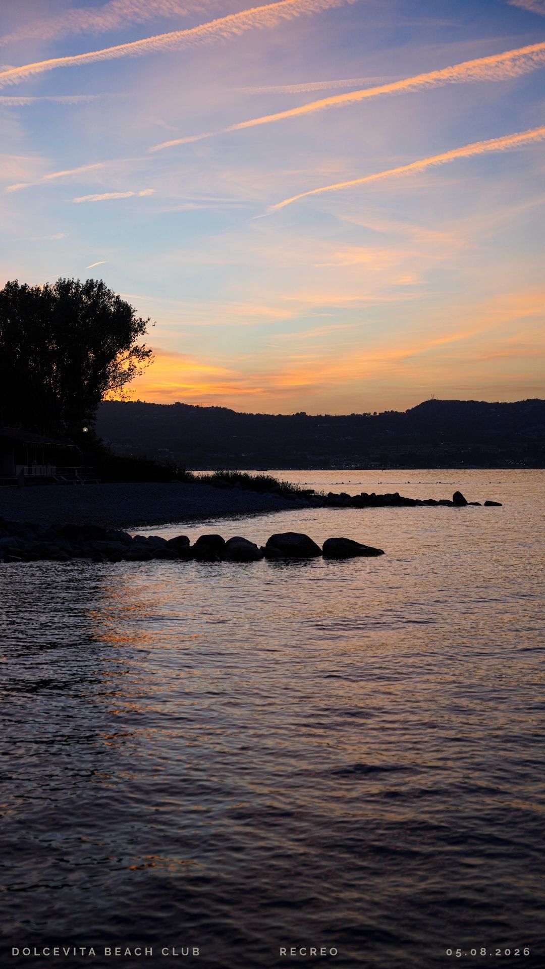 Tramonto dorato sul lago con scie luminose