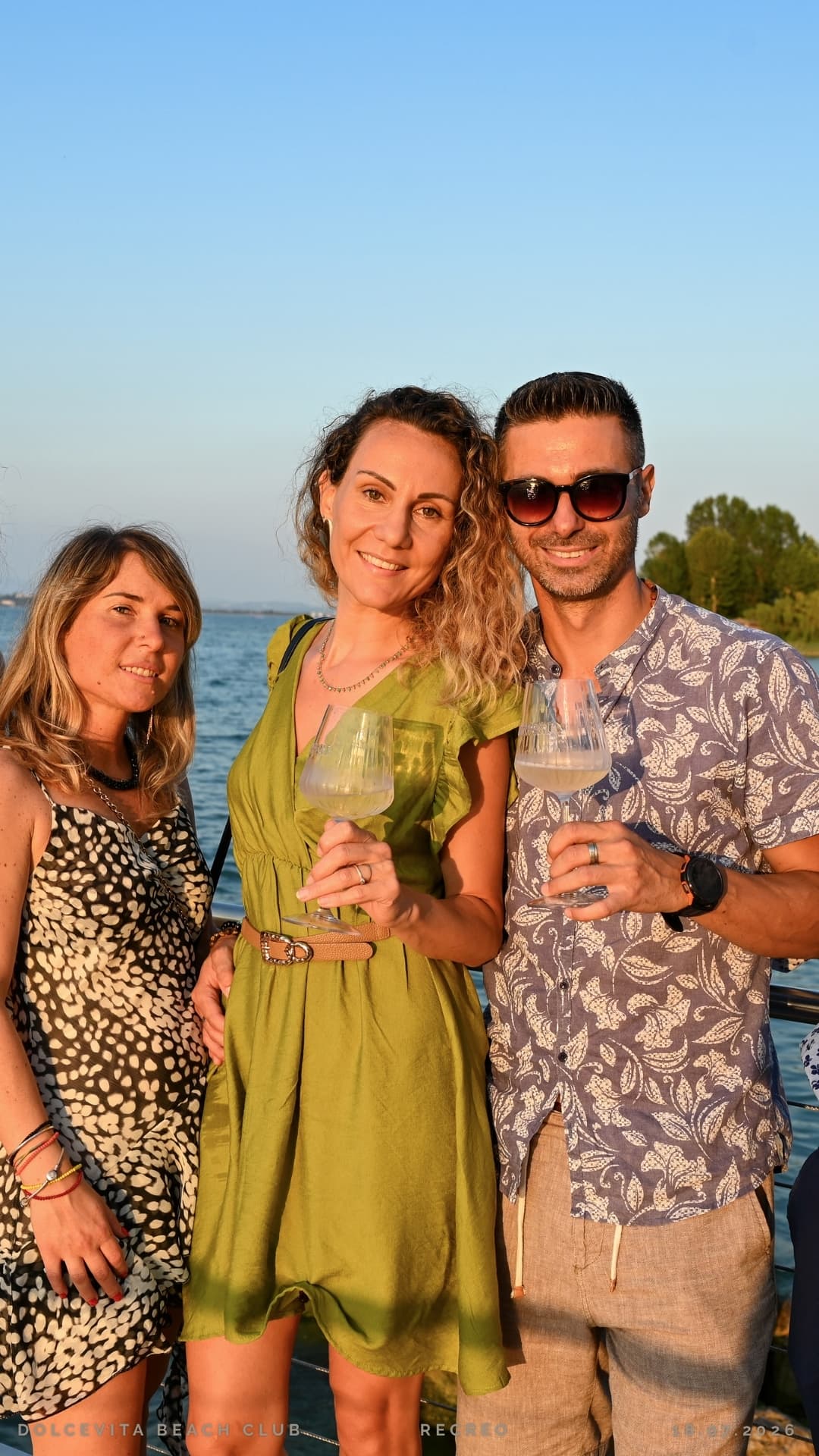 Tre ospiti brindano con calici di vino bianco