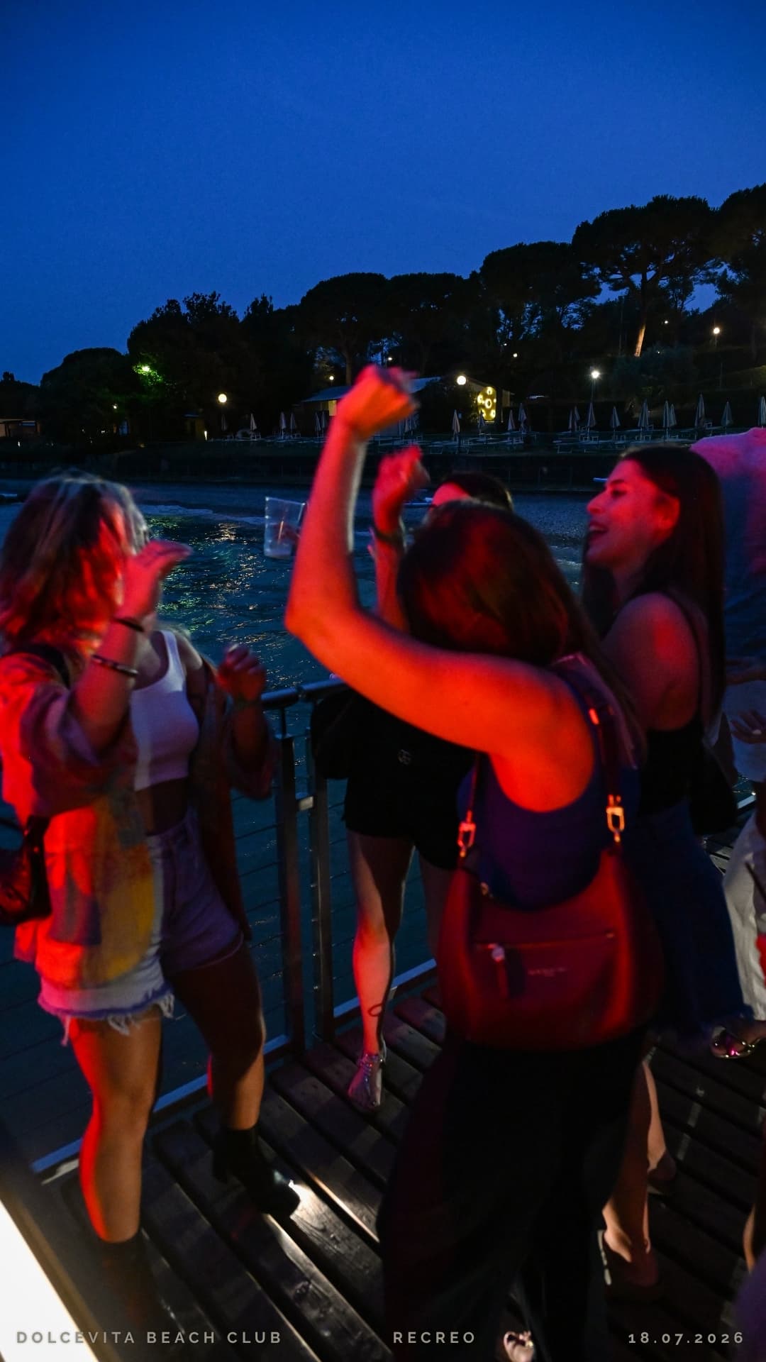 Gruppo di amiche che balla in riva al lago
