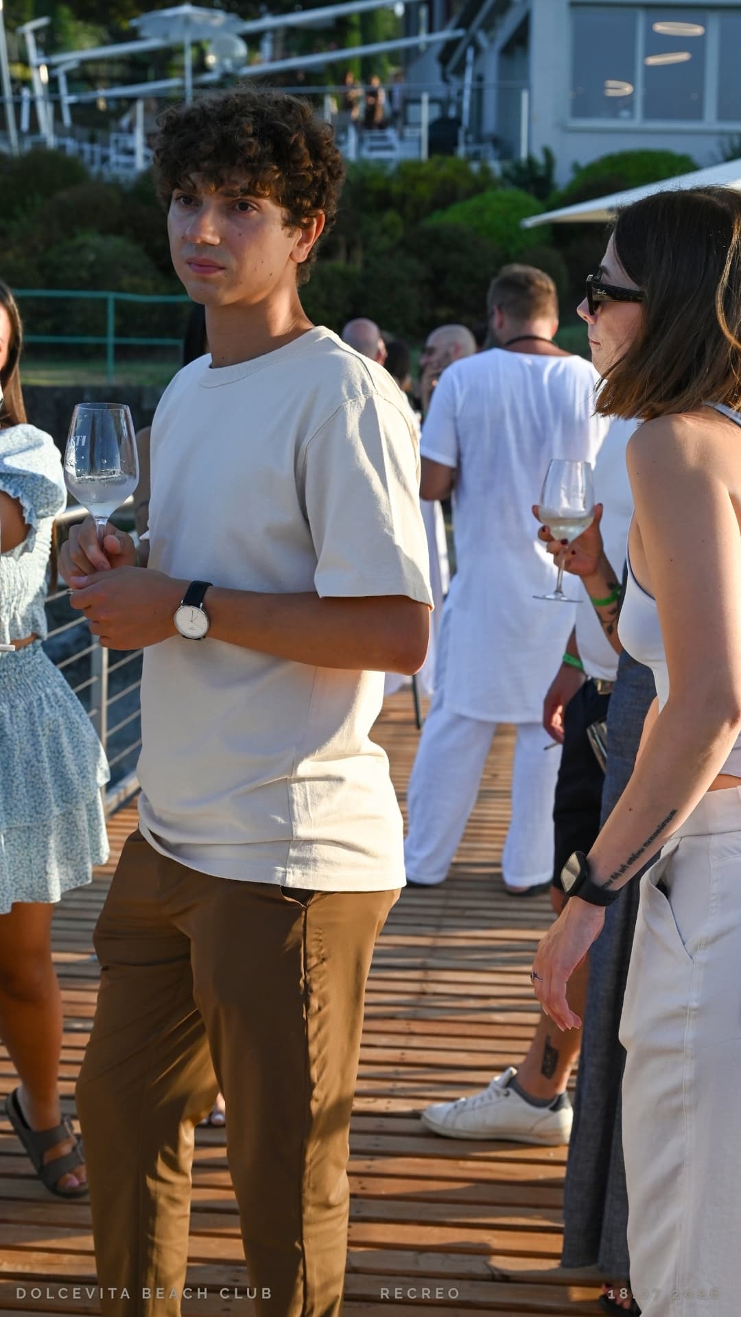 Ospite con calice di vino durante l'aperitivo al tramonto