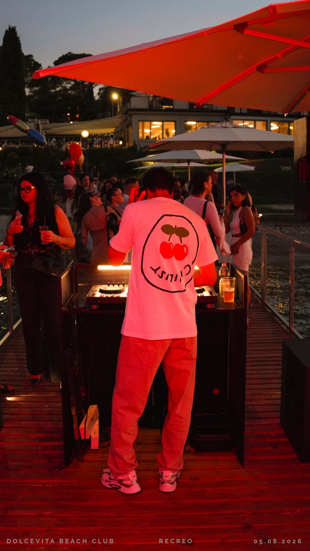 DJ alla consolle con luci rosse sul pontile