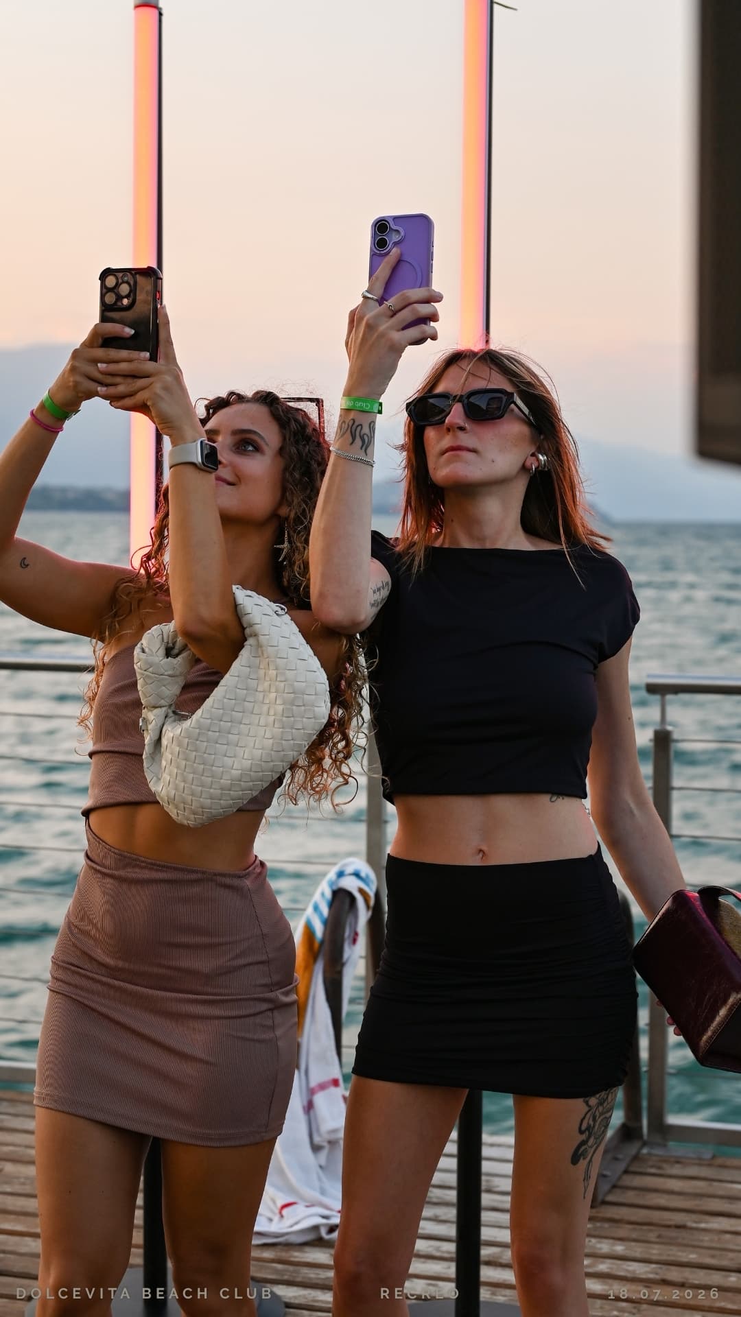 Due amiche riprendono il tramonto con lo smartphone