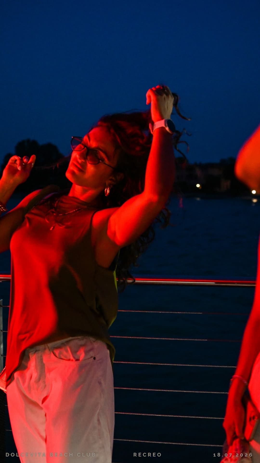 Ragazza balla nella luce rossa sul pontile