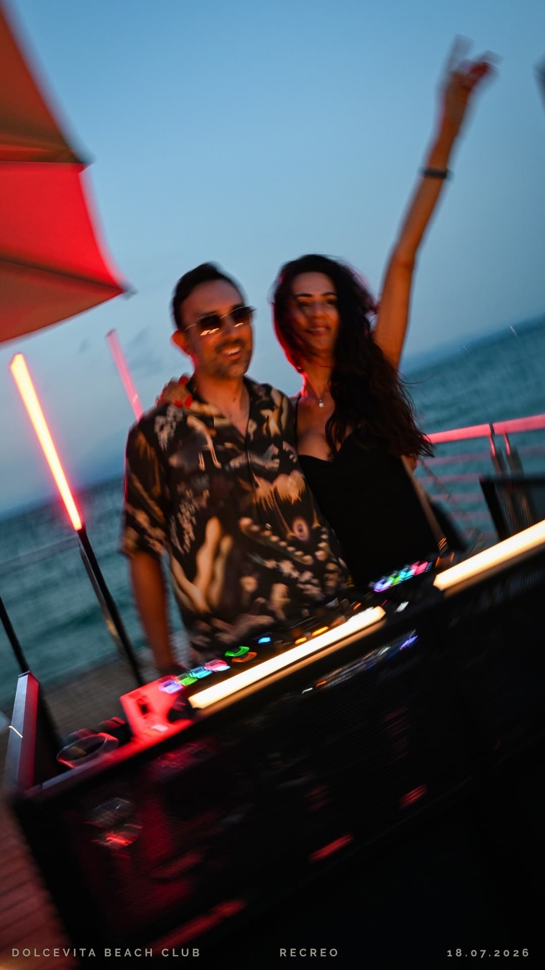 Dj e ragazza festeggiano con il braccio alzato