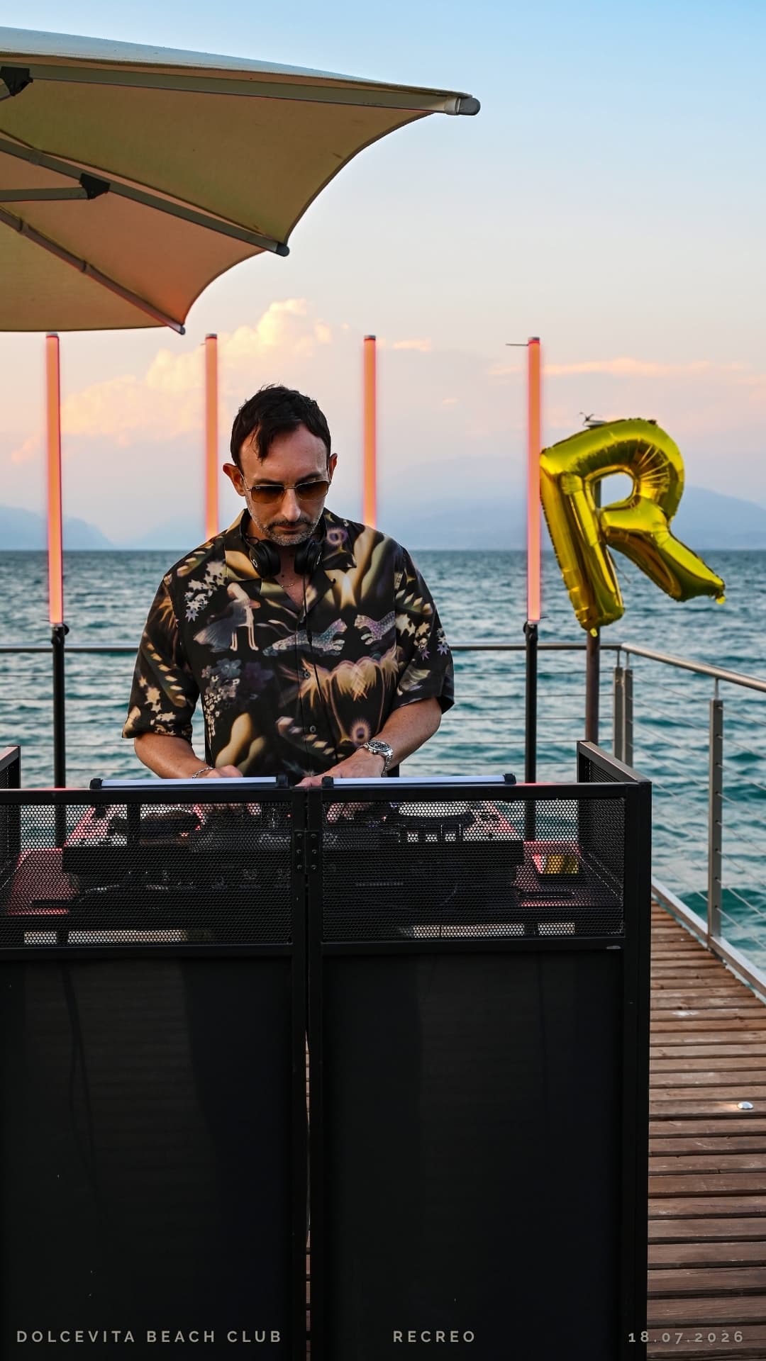 Dj alla consolle con il palloncino R sullo sfondo
