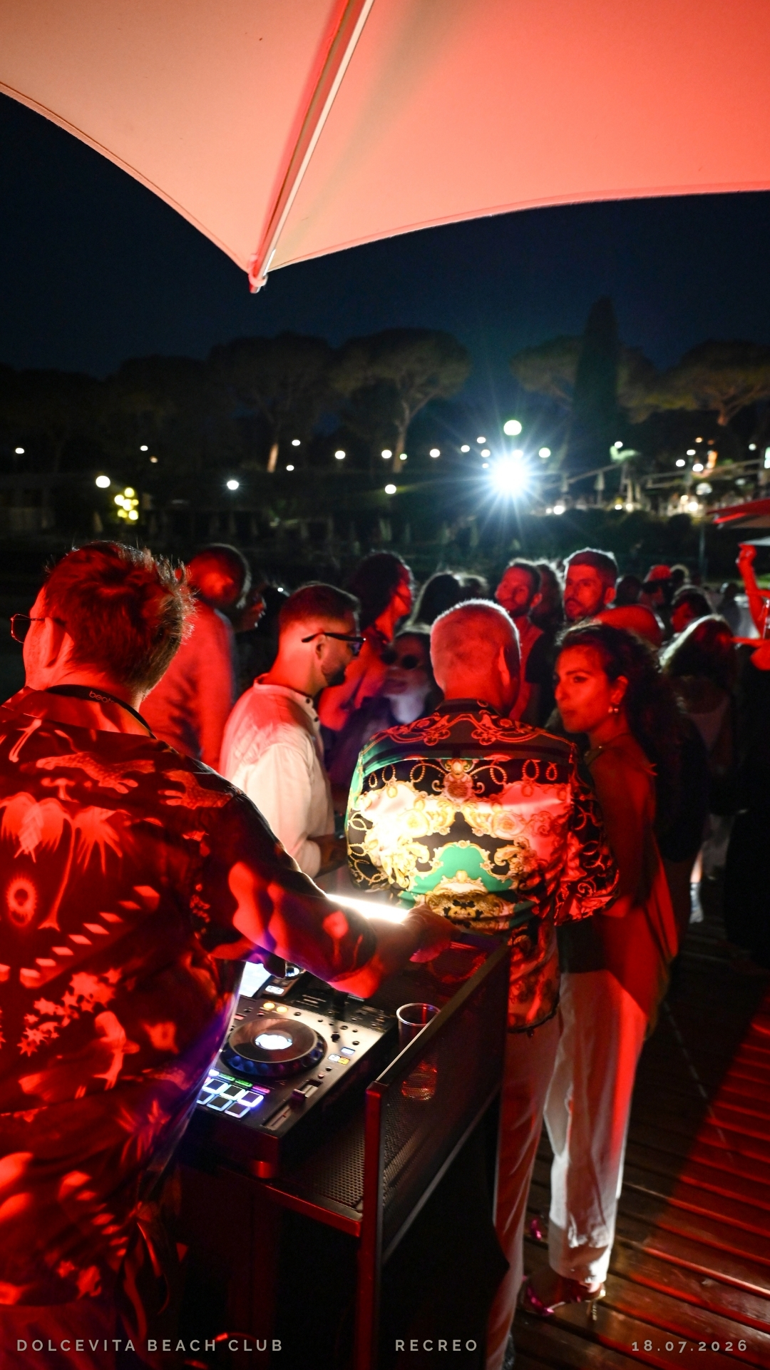 Ospiti davanti alla consolle sotto luci rosse