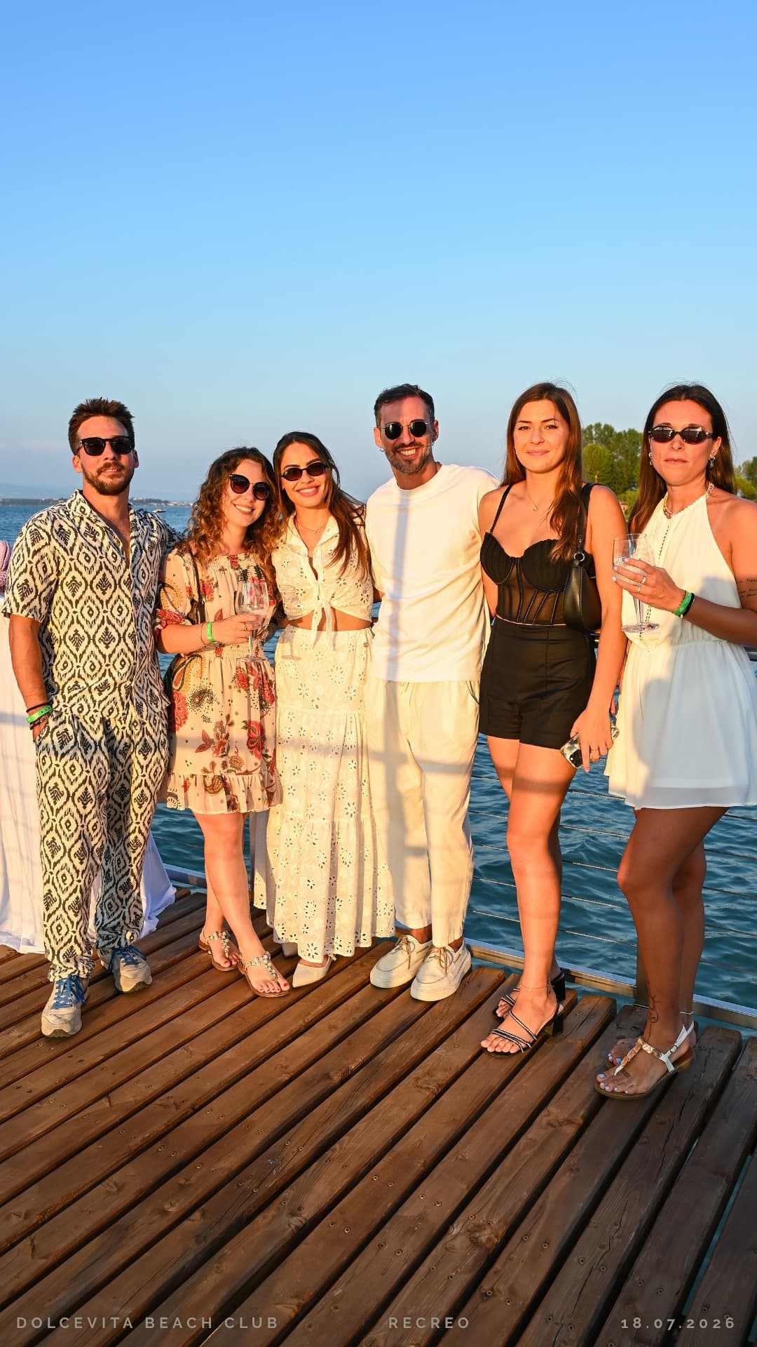 Gruppo di amici posa sul pontile nella luce dorata