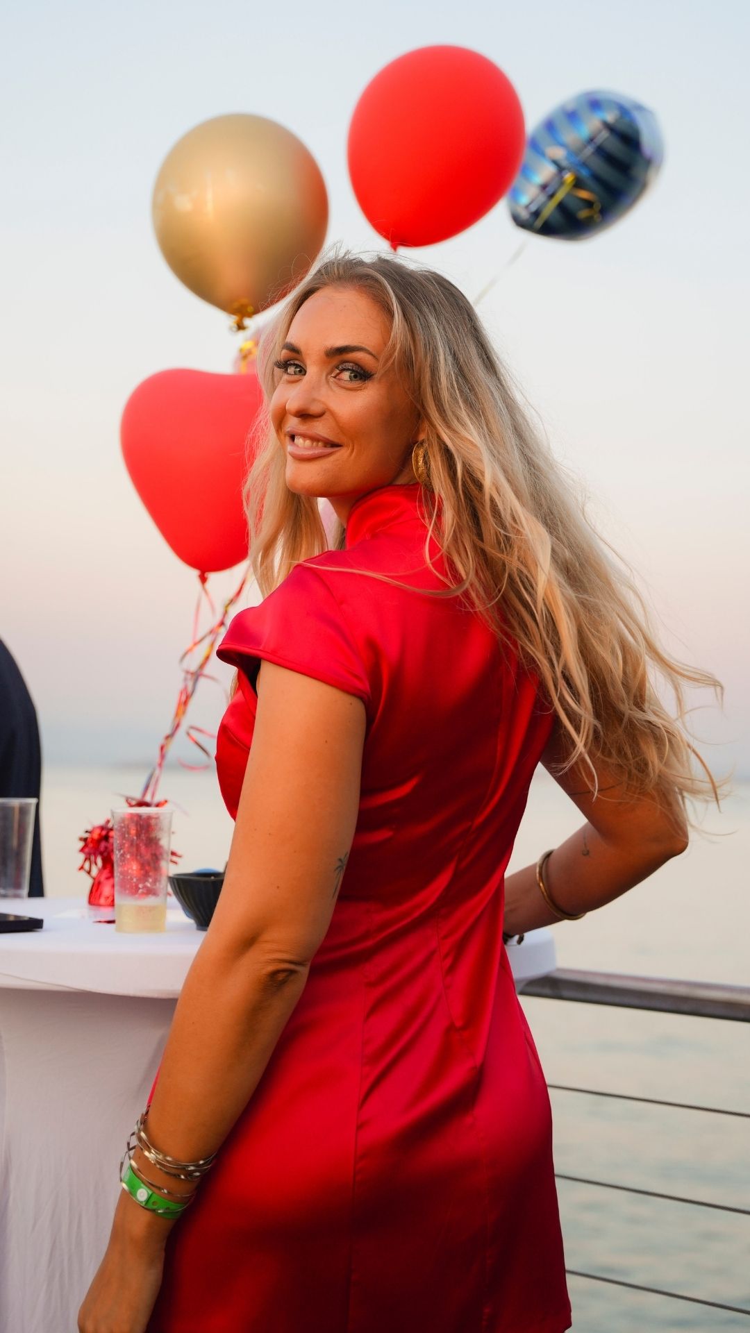 Ospite in abito rosso con palloncini colorati
