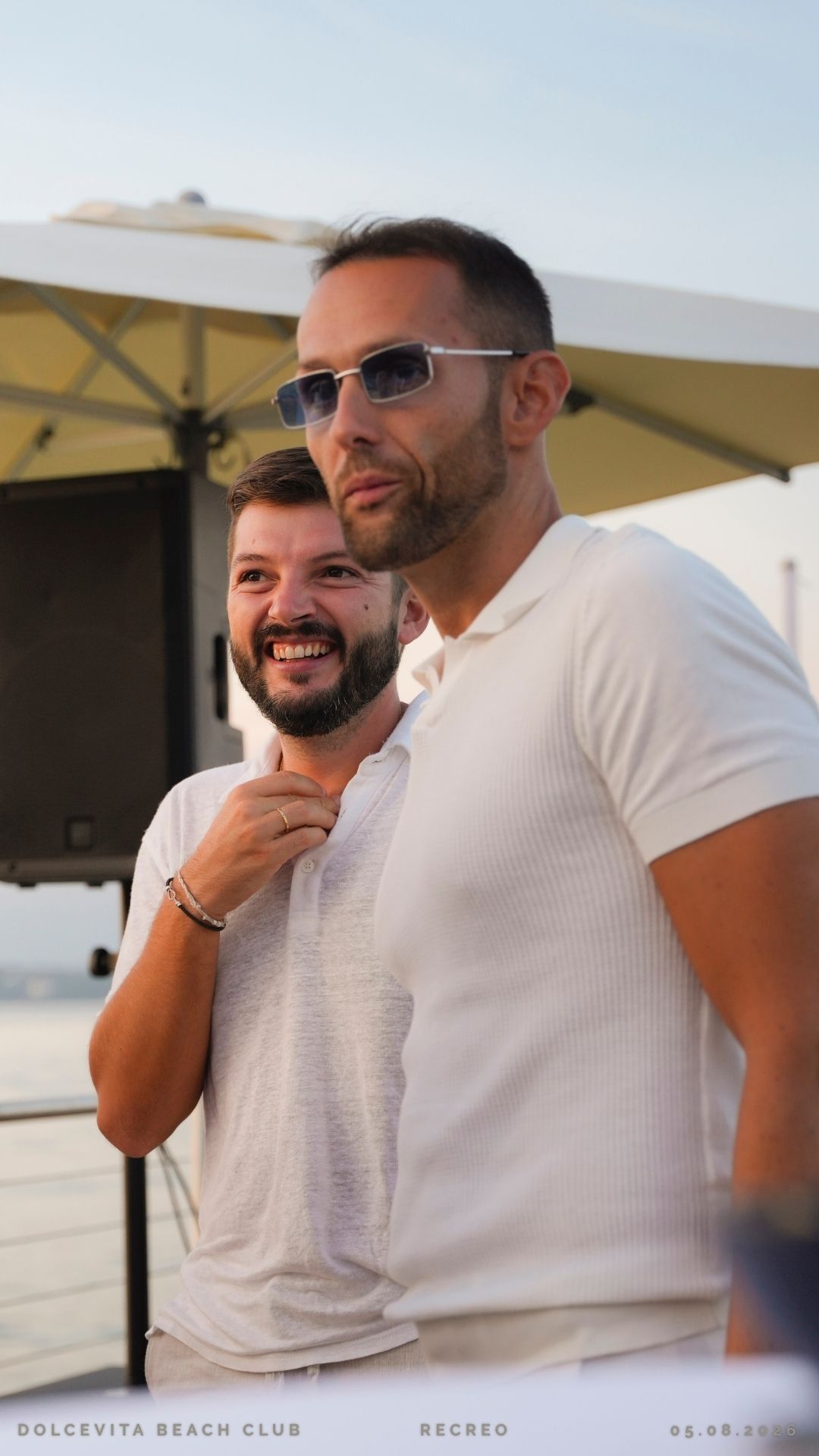 Due amici in polo bianca al tramonto