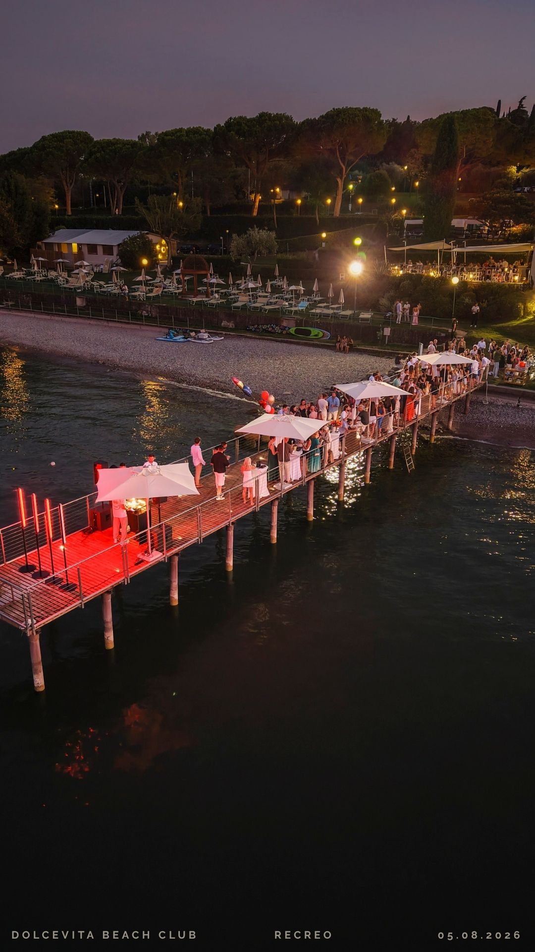 Pontile illuminato al tramonto con ombrelloni
