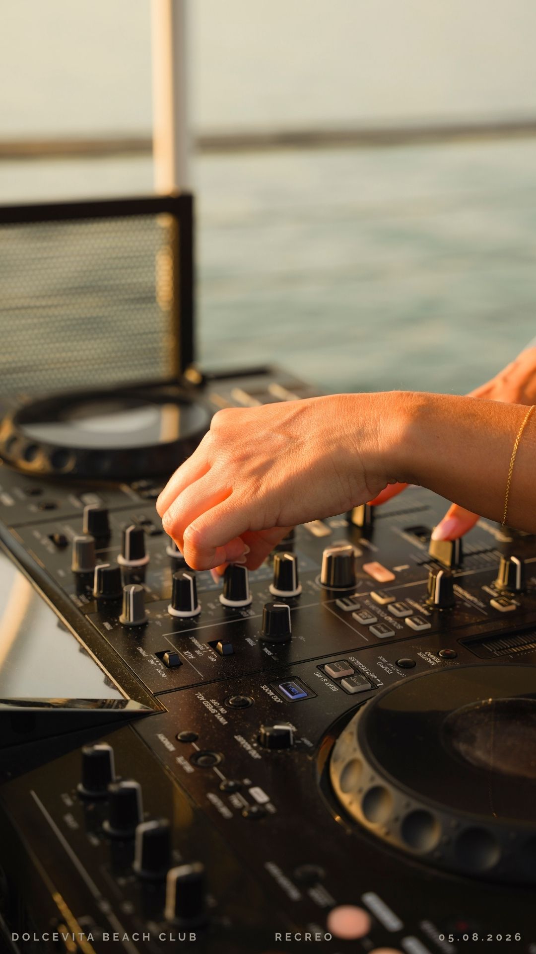 Mano del dj sulla consolle al golden hour