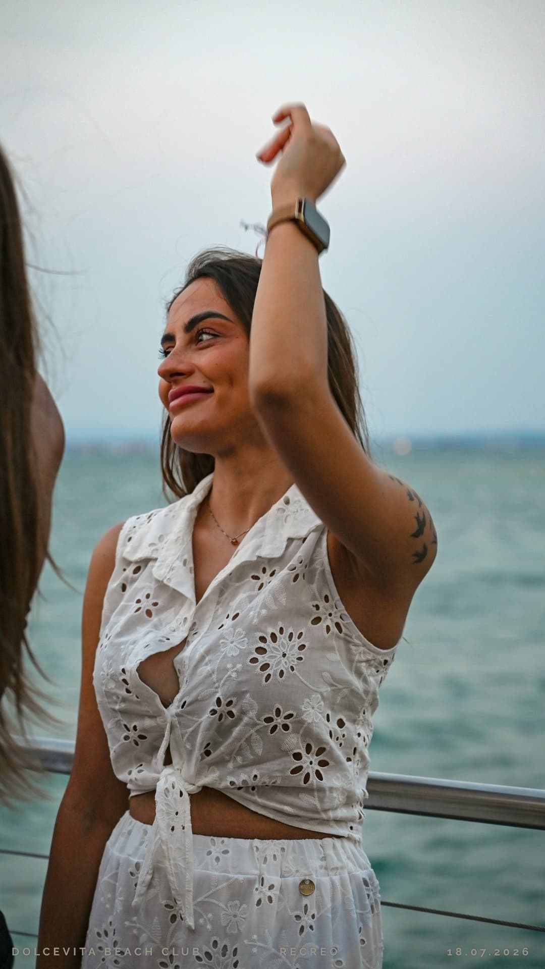 Ragazza balla con il braccio alzato davanti al lago