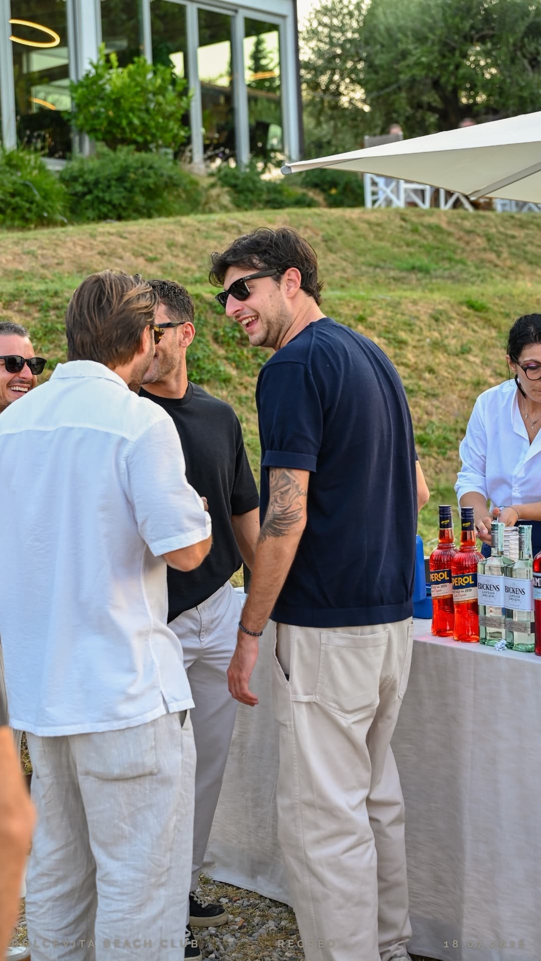 Amici ridono al banco bar durante l'aperitivo