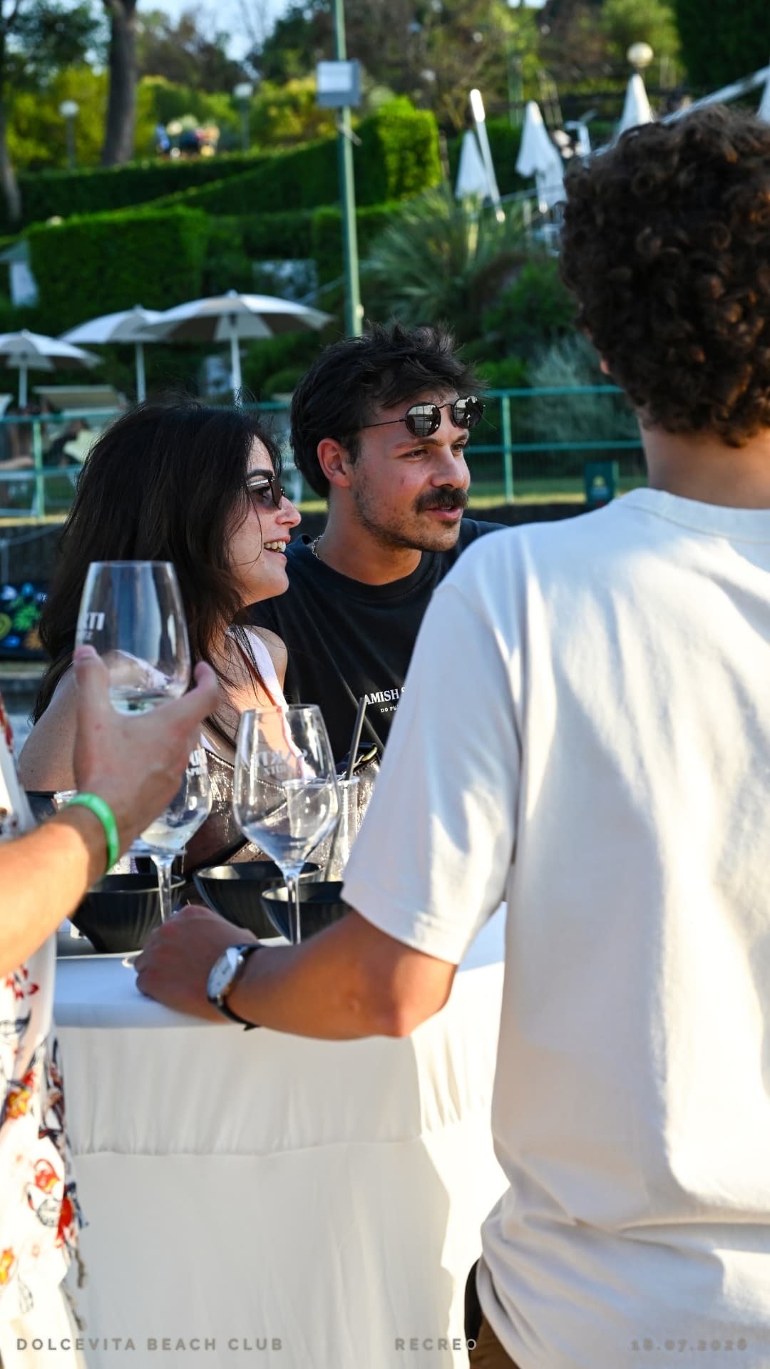 Amici brindano con calici di vino nella luce del tramonto