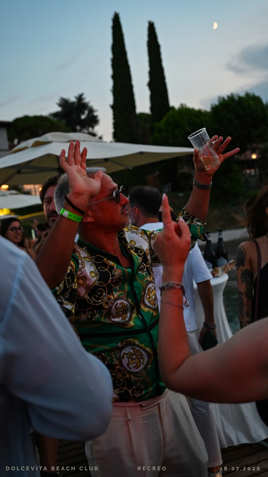 Ospite balla con le braccia alzate al tramonto