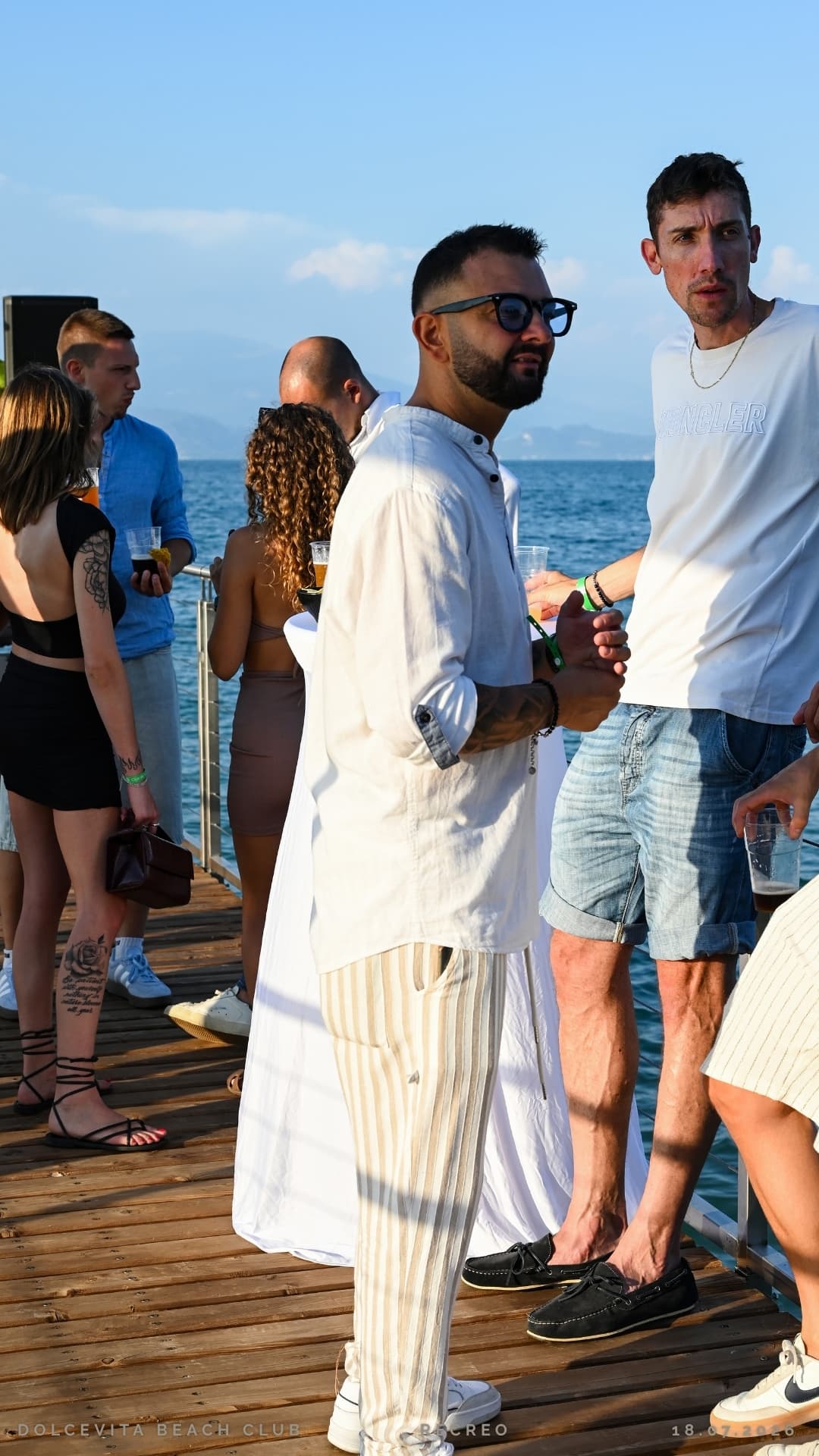 Gruppo di ospiti tra chiacchiere e aperitivi sul pontile