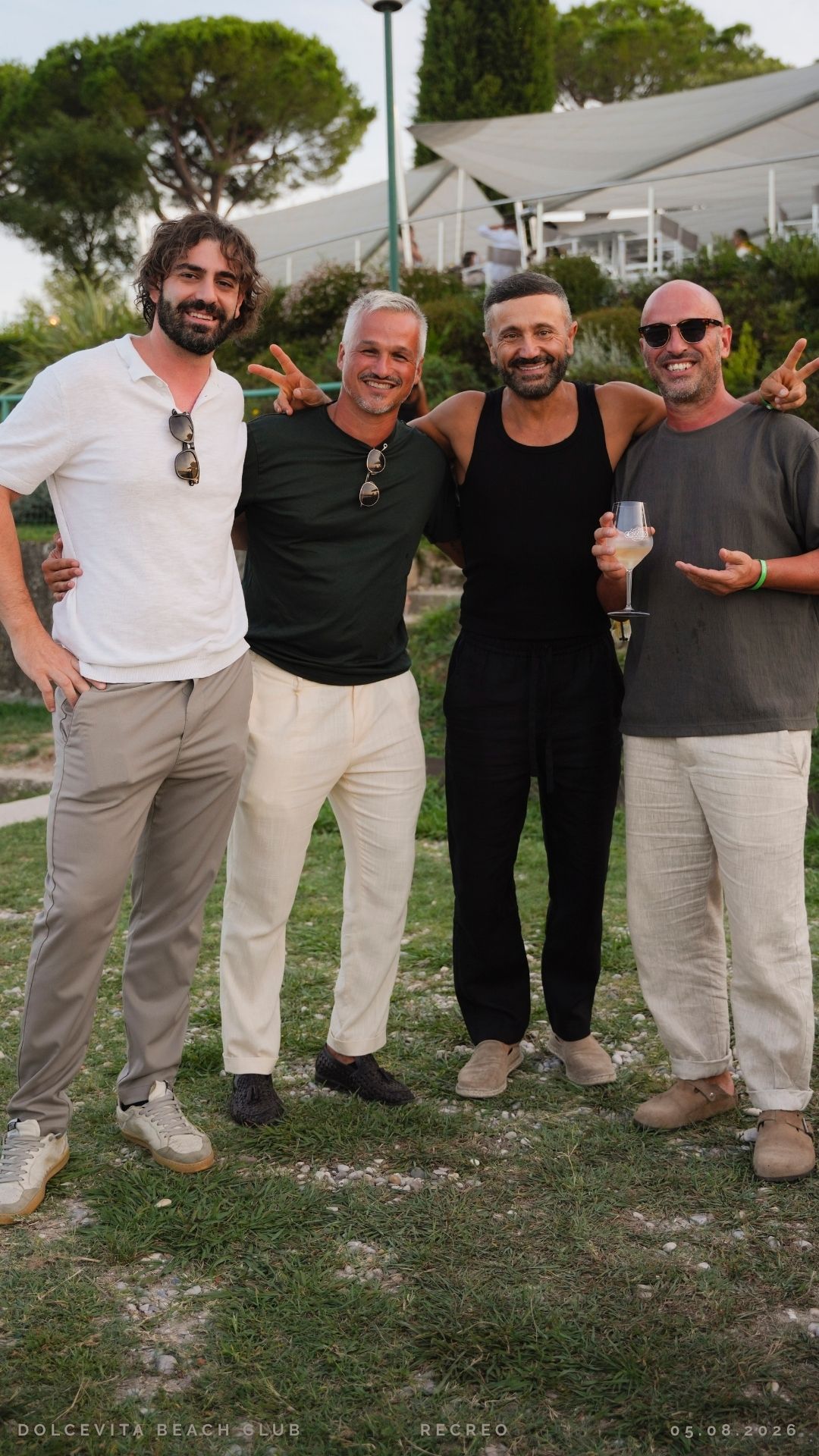 Quattro amici abbracciati sull'erba del resort