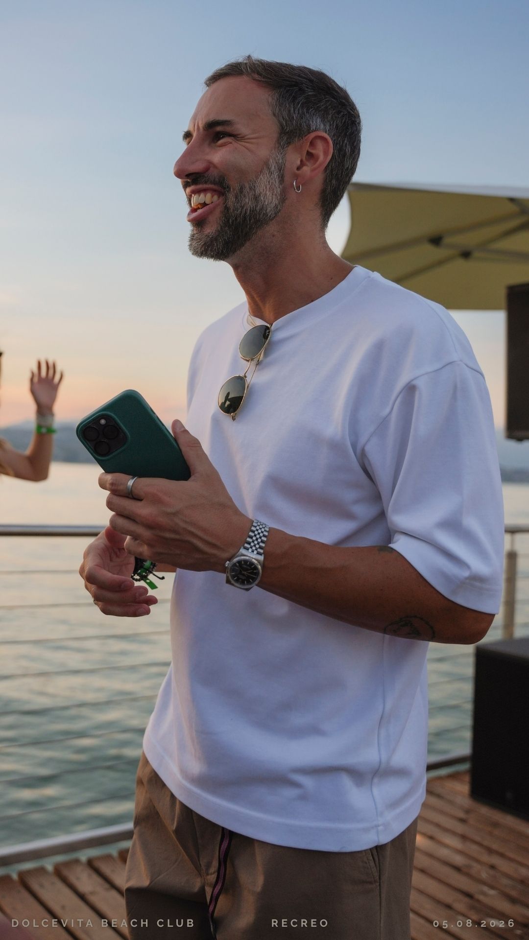 Ospite sorridente con smartphone al tramonto