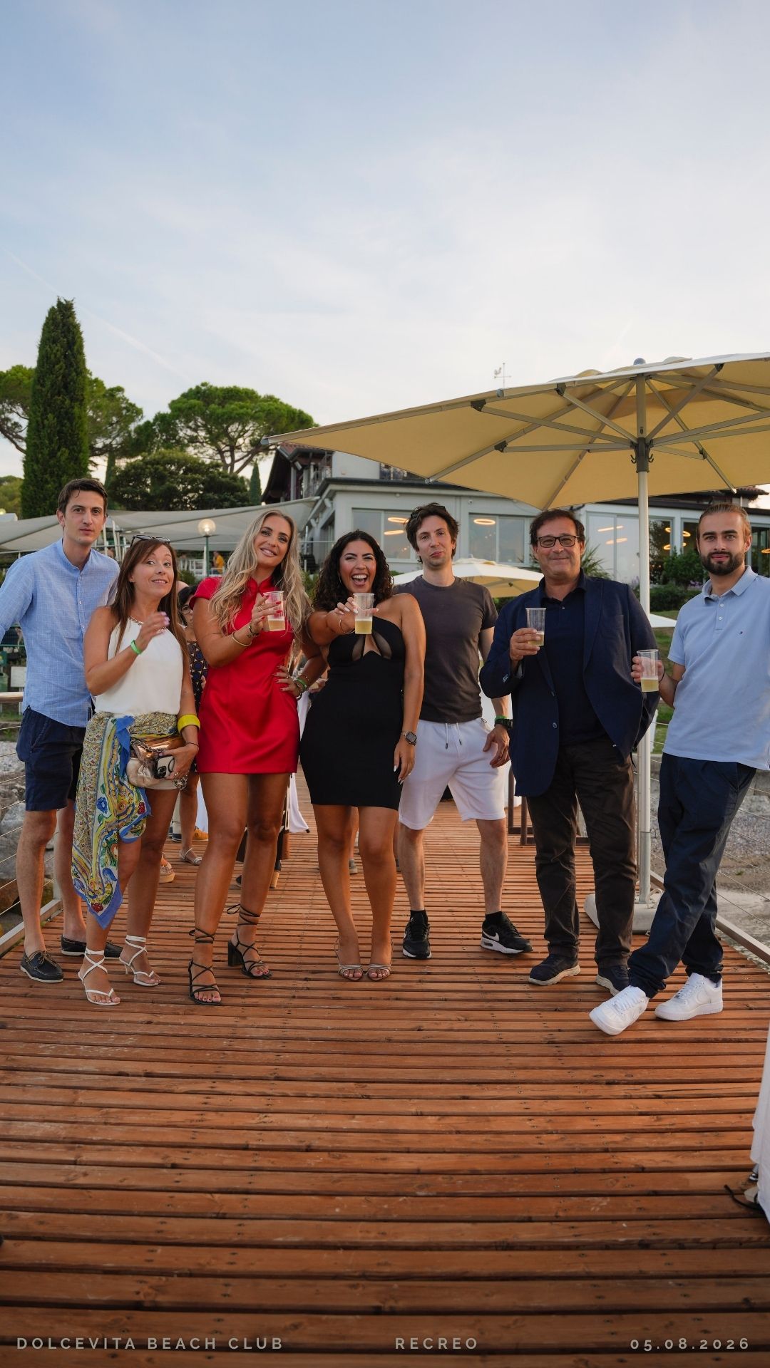 Gruppo di amici brinda sul pontile al tramonto